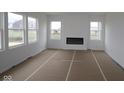 Bright living room featuring white walls, large windows, and a modern black fireplace at 17062 Cowbell Dr, Noblesville, IN 46060