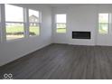 Bright living room with hardwood floors, modern fireplace and plenty of natural light from large windows at 17062 Cowbell Dr, Noblesville, IN 46060