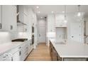 Gourmet kitchen with stainless steel appliances, white cabinetry, quartz countertops, and a large island at 19590 Wood Farm Pl, Westfield, IN 46074