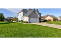 A bright lawn surrounds this lovely home with a big, attached garage at 2215 Golfside Dr, Lebanon, IN 46052