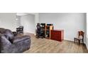 Comfortable living space with stylish wood flooring, a brown leather couch, and adjacent dining area at 286 Fairfax Ln, Greenwood, IN 46142