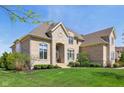 Beautiful two-story home with a manicured lawn, highlighted by the home's blend of stone and brick at 3384 Homestretch Dr, Carmel, IN 46032