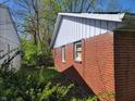 Side view of brick home, highlighting the white trim and green foliage at 3755 N Brentwood Ave, Indianapolis, IN 46235