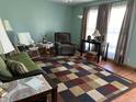 Inviting living room featuring bright windows, cozy seating, and colorful area rug on a wood floor at 3883 N 150 W, Columbus, IN 47201