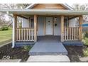 Inviting covered front porch with wooden railings, perfect for relaxing outdoors at 4325 Crittenden Ave, Indianapolis, IN 46205