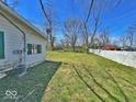 A spacious, green backyard with a white fence and mature trees creates a private outdoor oasis at 4520 Clinton St, Indianapolis, IN 46226
