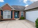 Close-up of front of home, featuring a blue front door, brick facade and attached garage at 4729 Beach Club Dr, Noblesville, IN 46062