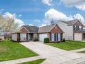 Inviting brick home with a concrete driveway and a manicured lawn under a blue sky at 4729 Beach Club Dr, Noblesville, IN 46062