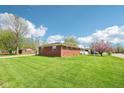 Expansive backyard with lush green lawn and mature trees surrounding the property at 4905 Candy Spots Dr, Indianapolis, IN 46237