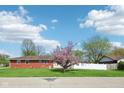 A beautiful brick house sits surrounded by a lush green yard and blooming trees at 4905 Candy Spots Dr, Indianapolis, IN 46237