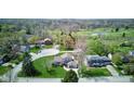 Aerial view of a home with a well-maintained lawn, mature trees, and a circular driveway at 4977 Beechwood Rd, Avon, IN 46123