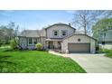 Charming two-story home featuring a well-manicured lawn, a brick and siding exterior, and an attached two-car garage at 4977 Beechwood Rd, Avon, IN 46123