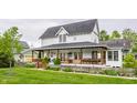 A two-story house with a covered front porch, wood railing, fenced yard, and lovely landscaped front yard at 5682 Upper Garden Way, Zionsville, IN 46077