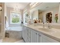Bright bathroom with double vanity, soaking tub, and elegant chandelier lighting at 6054 Easy Ln, Indianapolis, IN 46259