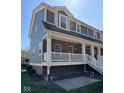 Beautiful two-story brick townhome with a spacious elevated porch and appealing architectural details at 6157 Winthrop Ave, Indianapolis, IN 46220