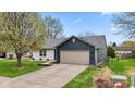Well-maintained home featuring a two-car garage, neat landscaping, and attractive exterior finishes at 6159 Connie Ct, Indianapolis, IN 46237