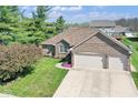 Beautiful aerial view of a brick home with a two car garage and a green yard at 6232 Buck Trail Rd, Indianapolis, IN 46237