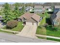 Overhead shot showcasing a brick home's front yard, garage, and surrounding neighborhood at 6232 Buck Trail Rd, Indianapolis, IN 46237