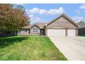 Charming brick home with a two-car garage, manicured lawn, and blossoming foliage at 6232 Buck Trail Rd, Indianapolis, IN 46237