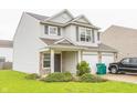 Two-story home featuring neutral siding, brick accents, attached two-car garage and well-maintained lawn at 6376 Matcumbe Way, Plainfield, IN 46168