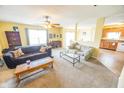 Comfortable living room featuring neutral walls, plush carpeting, ceiling fan, and ample natural light at 6376 Matcumbe Way, Plainfield, IN 46168