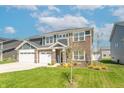 Inviting home with a three-car garage, nicely landscaped front yard, and classic architectural details at 7144 Hart St, Cumberland, IN 46229