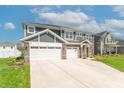 Stylish two-story house featuring a three-car garage, a large driveway, and landscaped front yard at 7144 Hart St, Cumberland, IN 46229