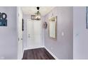Entryway featuring wood floors, lavender colored walls, decorative lighting, and a stylish mirror at 7618 Ballyshannon St, Indianapolis, IN 46217