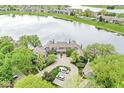 Scenic aerial view of lakeside townhomes with a circular driveway and green surroundings, showcasing the community's layout at 7786 Harbour Isle, Indianapolis, IN 46240