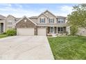 Beautiful two-story home with a three-car garage, landscaped lawn, and inviting front porch at 7829 Hedgehop Dr, Zionsville, IN 46077