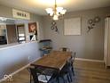 Dining room boasts stylish light fixture, decor, and wood-look floors at 798 S 600 W, New Palestine, IN 46163
