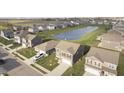 Aerial view of a residential neighborhood featuring well-maintained homes, green spaces, and a scenic pond at 813 Sonoma Ln, Greenfield, IN 46140
