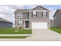 Charming two-story home with gray siding, stone accents, well-manicured lawn, and an attached two-car garage at 813 Sonoma Ln, Greenfield, IN 46140
