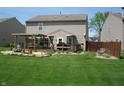 Spacious backyard showcasing a wooden deck with pergola, lush green lawn and garden at 9045 Stones Bluff Pl, Indianapolis, IN 46113