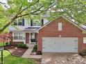 Attractive exterior view of the brick and vinyl two-story home with a well-maintained lawn and attached two car garage at 9099 Merrill Ct, Fishers, IN 46038