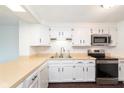 Bright kitchen features sleek, stainless steel appliances, white cabinets, and durable laminate countertops at 9467 Sandpiper W Dr, Indianapolis, IN 46268