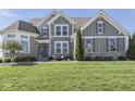 Charming two-story home featuring a stone facade, manicured lawn, and inviting front porch at 1051 Margate Dr, Greenwood, IN 46143