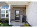 Welcoming front porch with a charming rocking chair and decorative touches at 10538 Rose Mill Dr, Lawrence, IN 46235