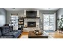 Cozy living area with brick fireplace, modern shelving, and sliding glass doors to the backyard at 106 W Delaware St, Fortville, IN 46040