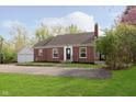 Lovely brick home showcasing a lush green lawn and a detached garage on a sunny day at 10745 Southeastern Ave, Indianapolis, IN 46239