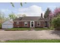 Attractive brick home with a well-manicured lawn and a detached two car garage at 10745 Southeastern Ave, Indianapolis, IN 46239