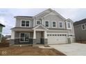 A two-story home with gray siding, stone accents, a two-car garage and a concrete driveway at 12417 Fresh Stock Dr, Noblesville, IN 46060