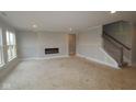 Living room with a modern fireplace and a staircase to the second floor at 12417 Fresh Stock Dr, Noblesville, IN 46060