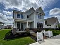 Inviting two-story home with a covered porch, manicured lawn, and a charming white picket fence at 1285 Chatham Hills Blvd, Westfield, IN 46074