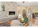Inviting living room featuring a stone fireplace, hardwood floors, and plenty of natural light at 13855 Waterway Blvd, Fishers, IN 46040