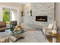 Comfortable living room showcases fireplace, stone wall accents, and access to the outdoor area at 13855 Waterway Blvd, Fishers, IN 46040