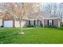 Inviting home with lush green lawn, brick facade, and a vibrant tree adding charm to the exterior landscape at 17027 Rainier Cir, Westfield, IN 46062