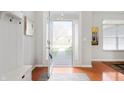 Bright foyer with hardwood floors, coat rack, and artwork, leading to a view of the front yard at 17027 Rainier Cir, Westfield, IN 46062