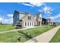 Beautiful new house with lovely landscaping, manicured lawn, and brick accents at 19472 Lewis Cir, Westfield, IN 46074