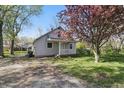Charming home featuring a cozy front porch and lush flowering tree in the front yard at 303 W 7Th St, Lapel, IN 46051
